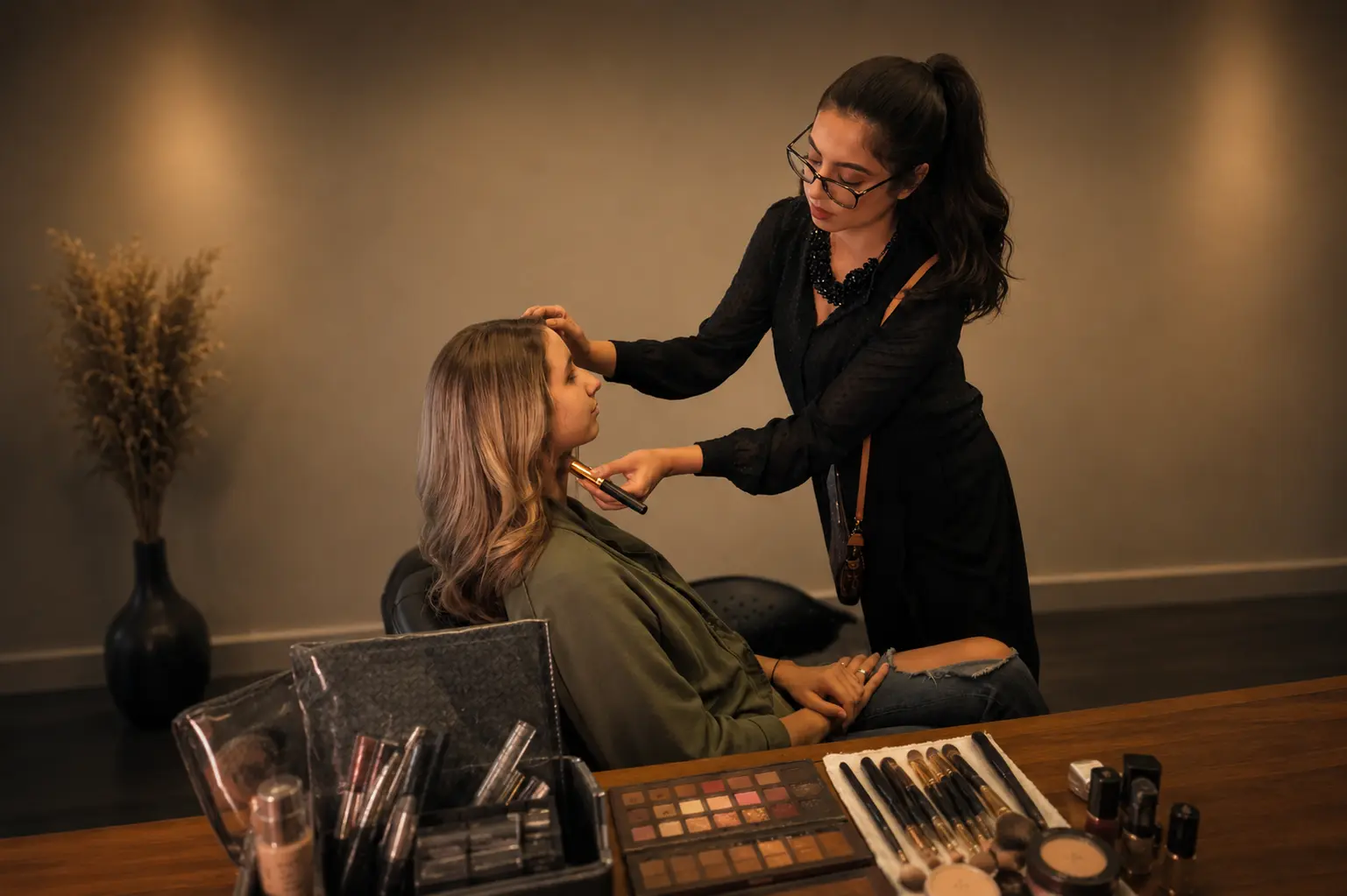 Nida applying makeup to a client — Makeup by Nida & Team